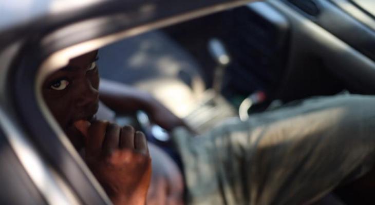 Person sitting in car looking up at the camera