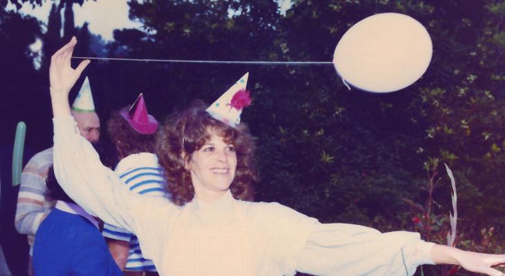 Gilda Rader wearing a party hat and holding a balloon