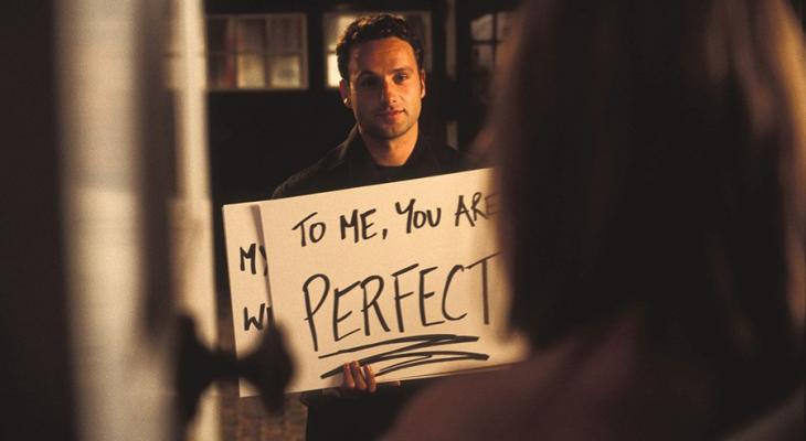 Man holding sign that says "To Me, You Are Perfect."