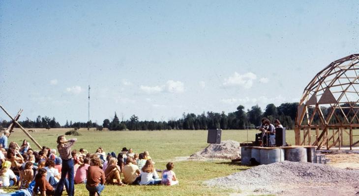 People sitting on a field listening to live music