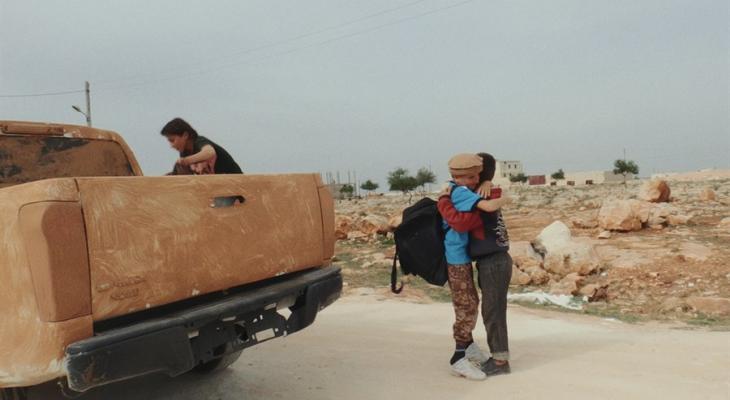 Two people hugging by a parked truck