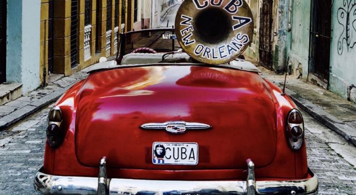 Red car with a tuba in the backseat