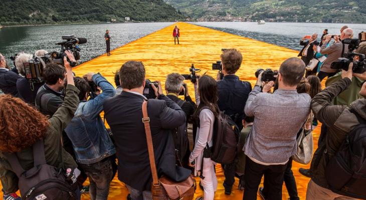 People photographing person walking on water