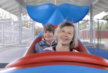 two women on a fish shaped carnival ride