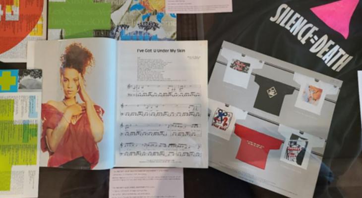 Multimedia display includes concert programs, photographs, graphic t-shirts and sheet music.