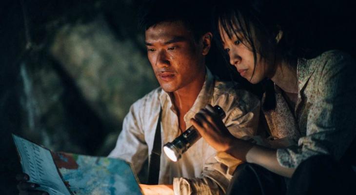 Two disheveled Hongkonger rebels study a map by flashlight. 
