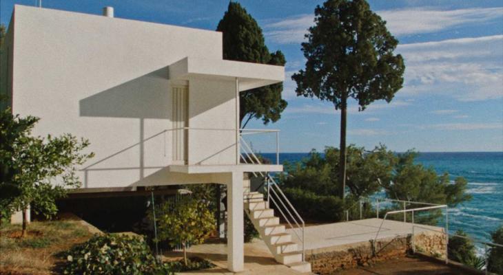 a white geometric house by the sea