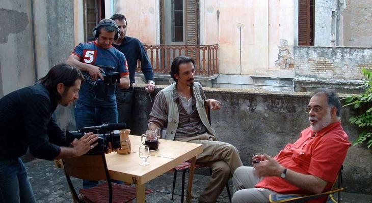 A film crew captures an interview with Francis Ford Coppola on a patio in Italy.