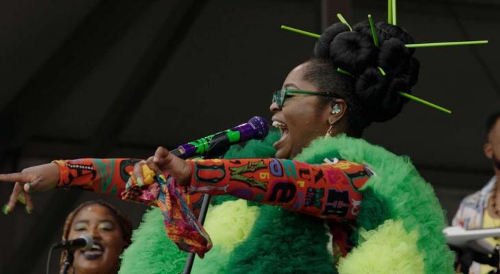 A singer performs in a bright green tulle costume. 