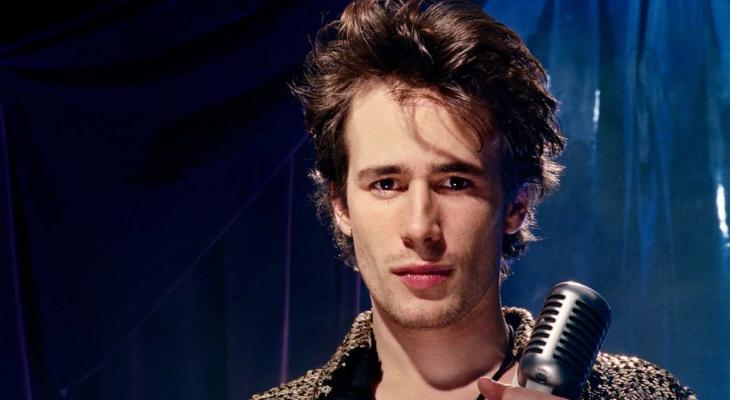 Jeff Buckley with a microphone looking at the camera