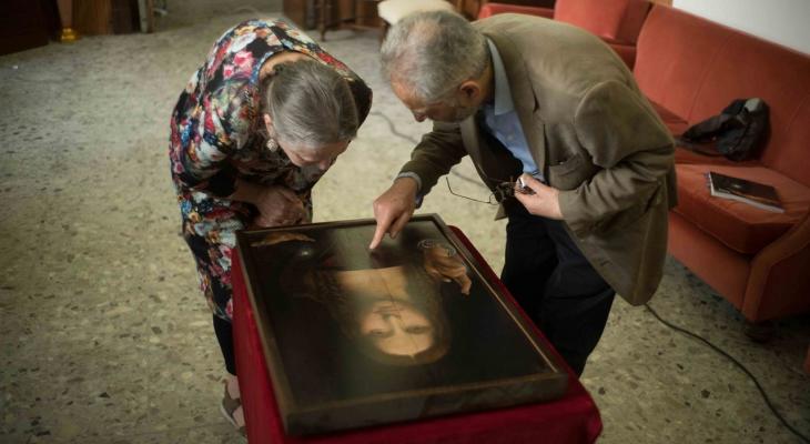 two people looking at a painting