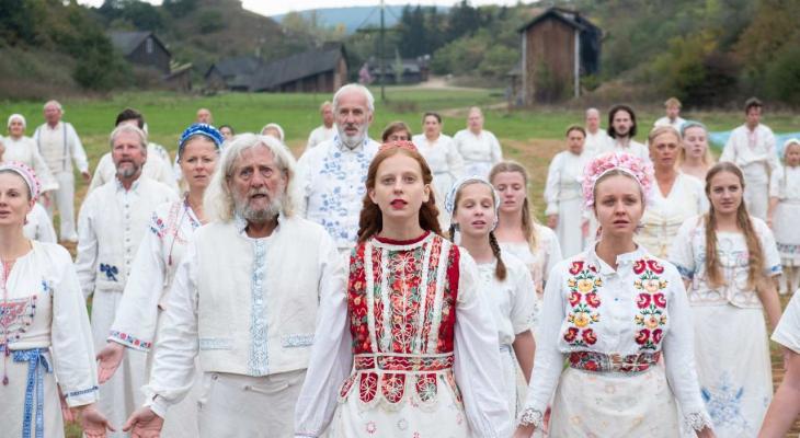 a large group of people in white standing together in a field