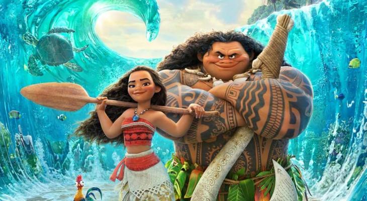 Moana and Maui standing together in front of waves