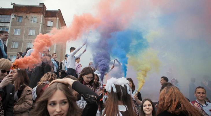 a group of students lighting up the sky with multi-coloured smoke