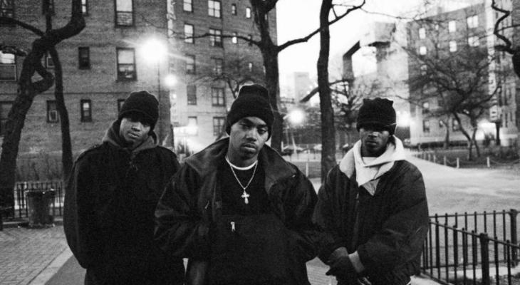 Nas stands with a member of his crew on each side.