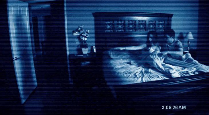 a woman and man in bed pointing at something next to the bed