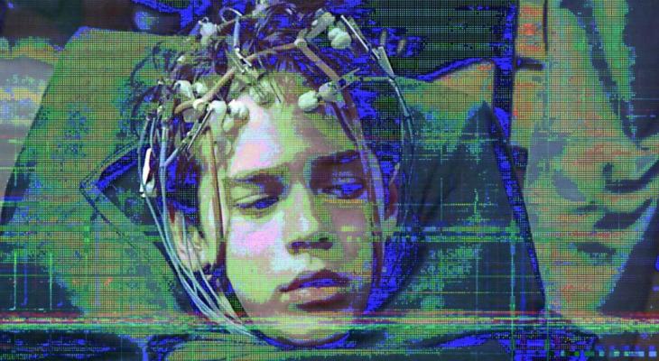 Highly pixellated image of a child with electronic sensors attached to their head.