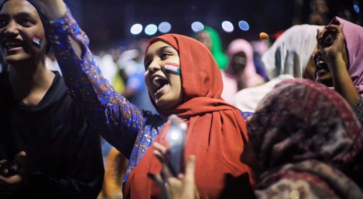 a woman with a flag painted on her cheek surrounded by people
