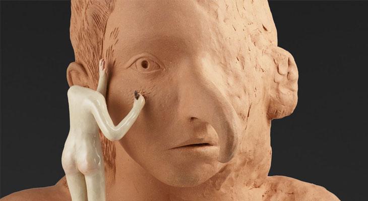 Terracotta bust being sculpted by a small, white, headless figure