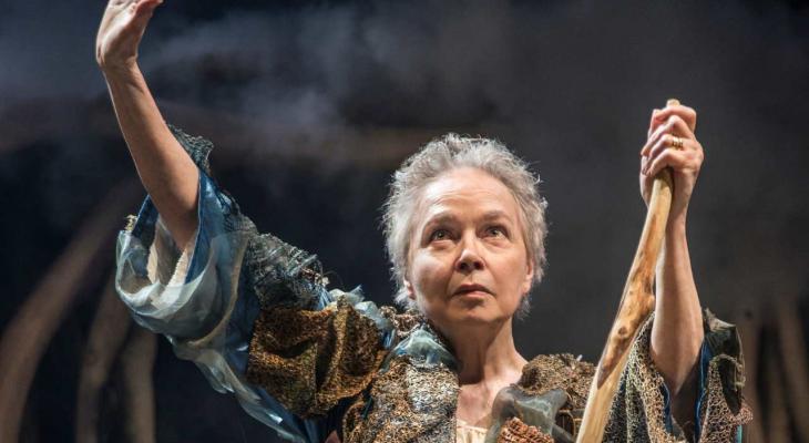a woman holding a staff and raising her arm in the air