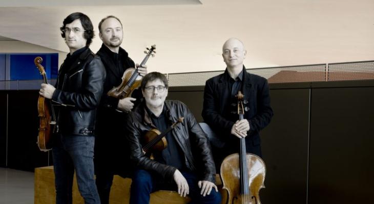 The four members of Quatuor Danel posing around a yellow sofa with their strings.