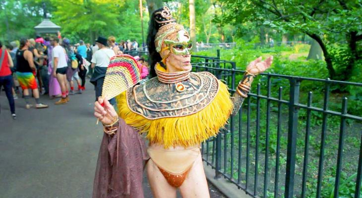 A drag queen elder poses in a park.