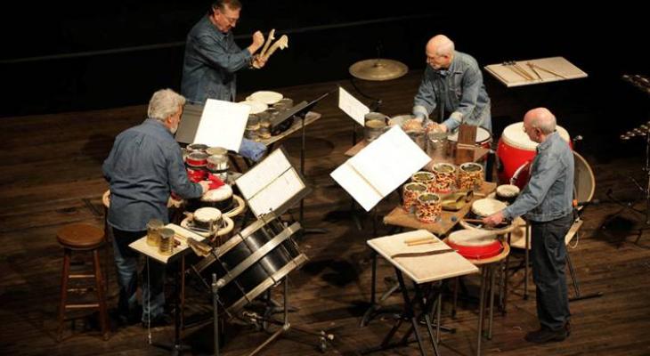 Four members of NEXUS perform on a stage with percussion instruments.