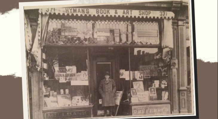 Greyscale picture of a man standing in front of Hymans Book & Arts Shop in Kensington Market