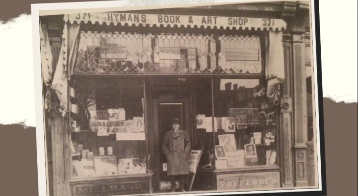 Greyscale picture of a man standing in front of Hymans Book & Arts Shop in Kensington Market 