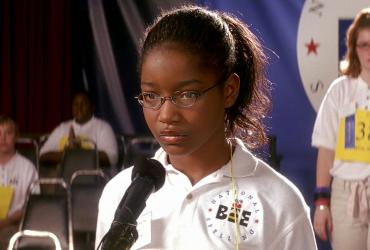 A young girl considers her response to a spelling bee question.