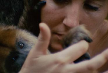a woman holding a monkey's paw in her hand