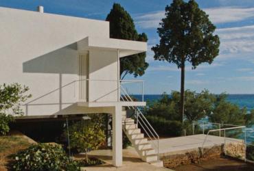 a white geometric house by the sea