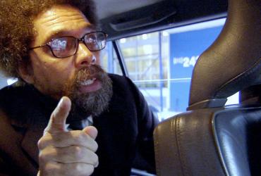 a man with a beard and glasses in the back of a car