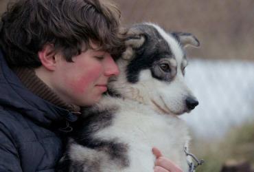 a man embracing a dog