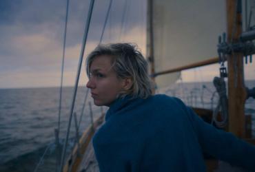 a woman looking over her shoulder on a sailboat