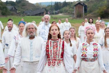 a large group of people in white standing together in a field