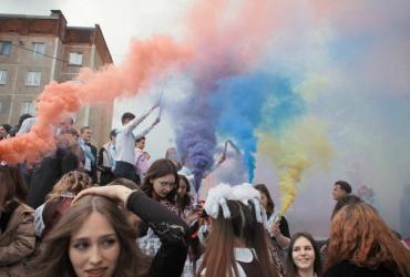 a group of students lighting up the sky with multi-coloured smoke