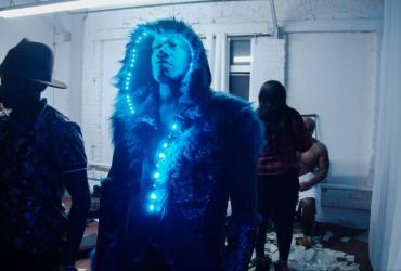 a man in a fur trimmed hood adorned with string lights