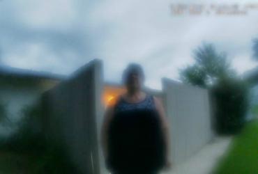 a blurry image of a woman standing in front of a house