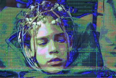 Highly pixellated image of a child with electronic sensors attached to their head.