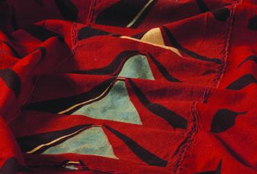 Close-up of red fabric with white triangles stamped down the centre