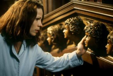 Lili Taylor looking at a staircase with carved faces