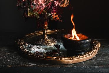 Close up image of a candle and a flower bouqet