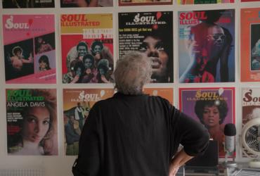 Regina Jones examines covers of Soul magazine mounted on a wall.