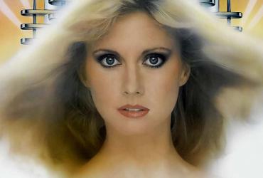 Olivia Newton-John with her hair blowing in the wind and dark eyeliner