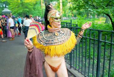 A drag queen elder poses in a park.