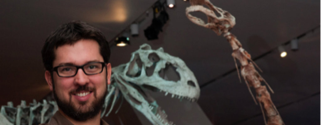 David Evans standing in front of dinosaur skeletons